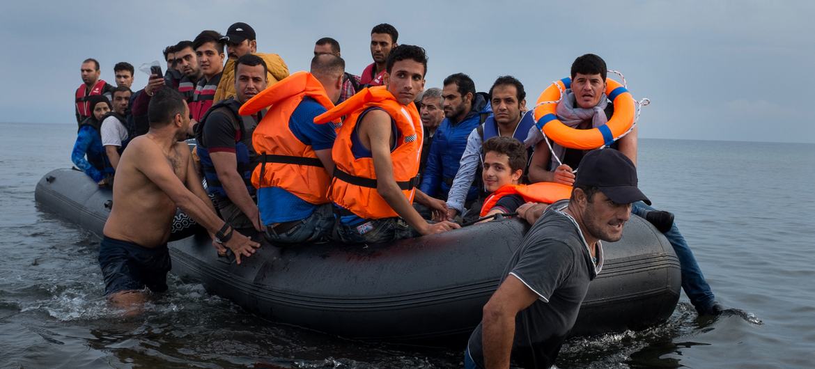 یک قایق لاستیکی بزرگ پر از پناهجویان به ساحل جزیره لسبوس در منطقه دریای اژه شمالی کشیده می شود.  (فیله)