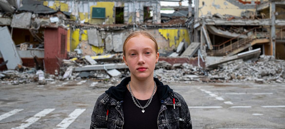یک دختر دوازده ساله در مقابل مدرسه خود ایستاده است که در جریان درگیری در خارکف اوکراین در حمله هوایی ویران شده است.